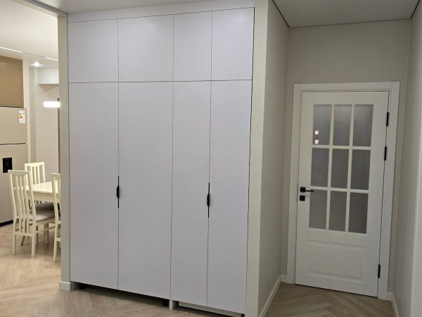 Встроенный хозяйственный шкаф с техникой — стиральная и сушильная машина скрыты за фасадами